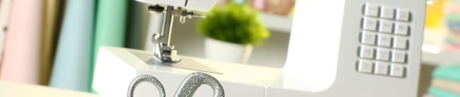 Verschiedene Nähwerkzeuge auf einem hellen Tisch: moderne Nähmaschine, Stoffscheren, Maßband, Stoffmarkierer und Nähclips in einer gemütlichen Nähumgebung.