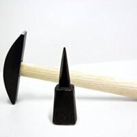 Das Cajou-Sensenzubehör besteht aus einem Dengelhammer und einer Amboss in der Form eines flachen Kreises. Beide Teile sind robust und langlebig.
