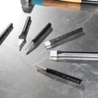 Multifunktionales Werkzeugset mit 6 Teilen, bestehend aus Meißeln, Durchtriebern und Körnern, gefertigt aus Chrom-Vanadium-Stahl und befestigt in Kunststoffständern.